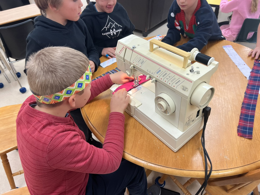 Group of students using a sewing machine